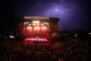 Blick auf die Bühne bei Das Fest in Karlsruhe mit einem Gewitter im Hintergrund.