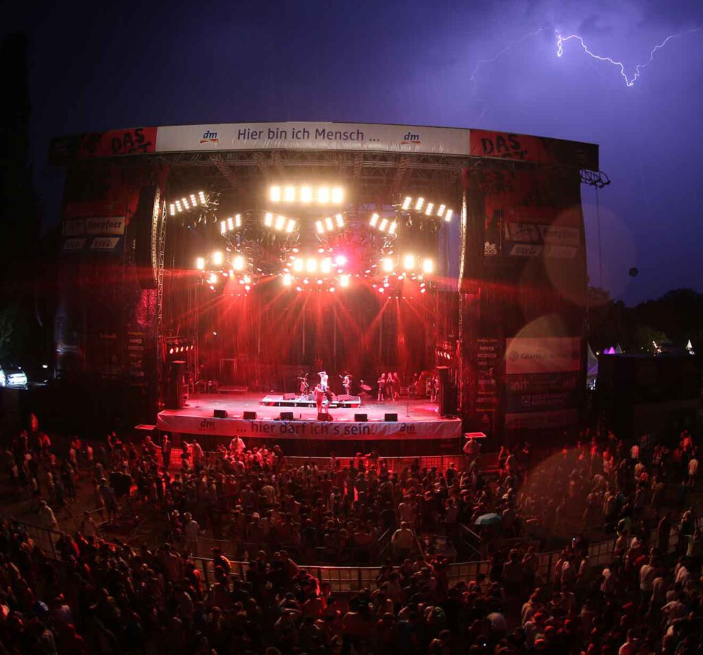 Festivalbühne bei Gewitter mit Blitz am Himmel – Symbol für Wetterberatung bei Großevents.